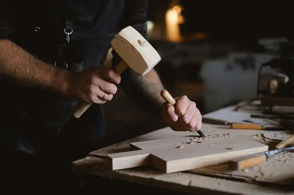 Woodworker carving a custom wooden toy at a workbench