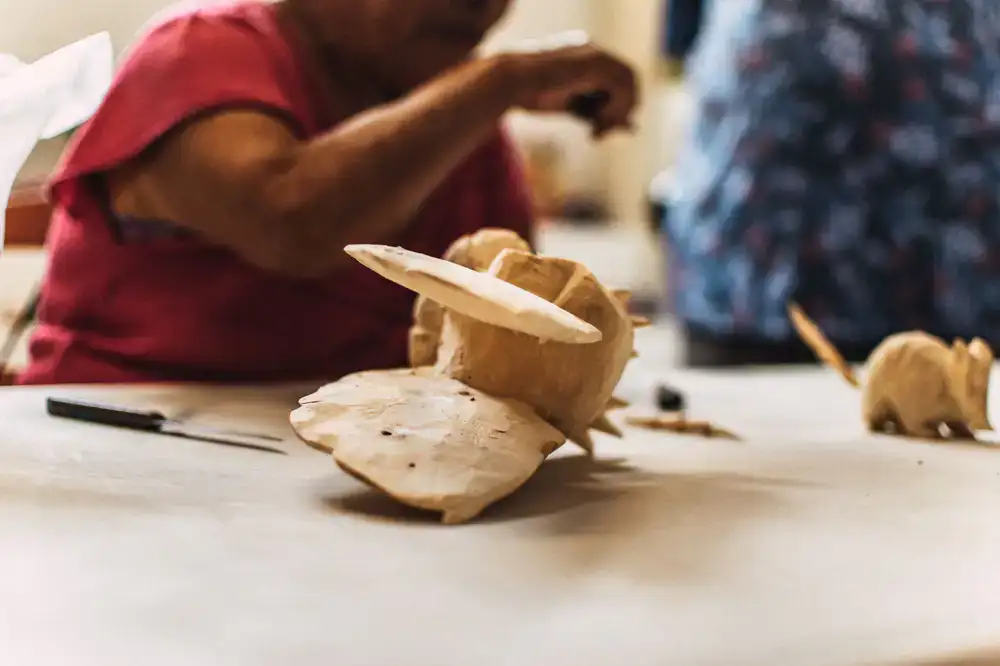 Craftsman working on a wooden toy in a warm workshop