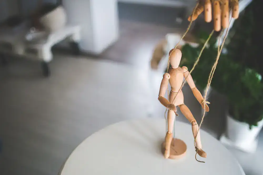 A wooden bear marionette with simple strings